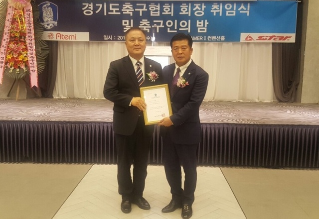 ▲ 이석재 통합 경기도축구협회 회장(오른쪽)이 21일 수원 WI웨딩홀에서 열림 취임식 겸 축구인의 밤 행사에서 최규진 도체육회 사무처장에게 인준패를 전달받은 뒤 기념촬영을 하고 있다.홍완식기자