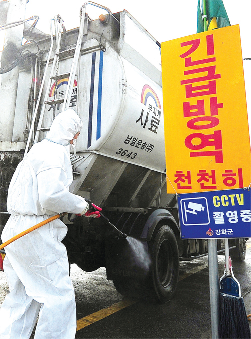 인천 강화 거점 소독 전국적으로 고병원성 AI가 빠른 속도로 확산되고 있는 가운 데 12월8일 인천시 강화군 초지대교 인근 도로에서 축산차량 거점소독을 하고 있다.