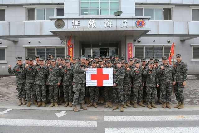 ▲ 해병대 제 2사단 12대대 화기중대원 총원들이 헌혈증 101장이 붙혀진 판넬을 들고 기증하기 전 파이팅을 외치고 있다. 해병대2사단 제공