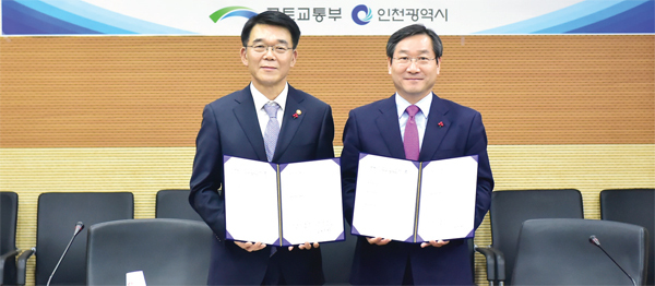 유정복 인천시장이 지난 2015년 12월 16일 서울 동작역 인근 한강홍수통제소 대회의실에서 강호인 국토교통부장관과 경인고속도로 이관 협약서에 서명 후 기념촬영을 하고 있다.