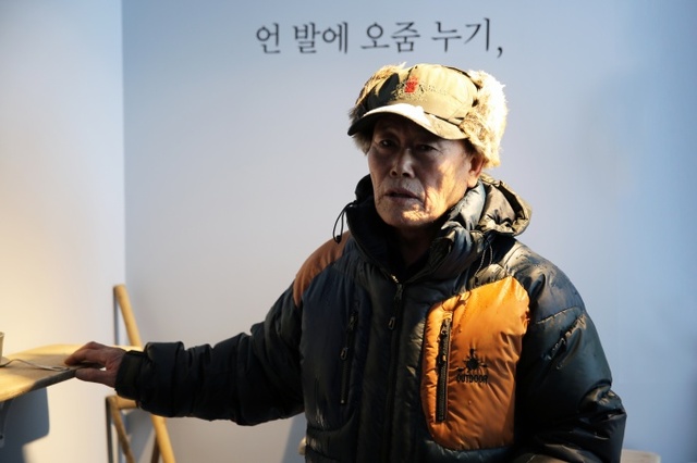 ▲ 선감학원 수용자로, 직원으로 그리고 선감도 주민으로 22년을 살았던 김춘근씨가 본인의 삶을 구성한 전시를 설명하고 있다