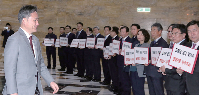 ▲ 여성 모독과 성희롱·노인 폄하 논란에 휘말린 더불어민주당 표창원 의원이 1일 오후 국회 본회의장 입구에서 자신의 사퇴를 촉구하는 새누리당 의원들 사이로 입장하고 있다. 연합뉴스