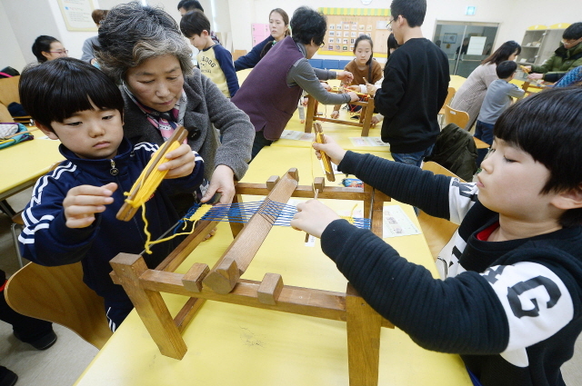 ▲ 26일 오후 휴일을 맞아 인천시 연수구 인천시립박물관을 찾은 가족단위 나들이객들이 호기심 어린 모습으로 길쌈체험을 하고 있다.장용준기자