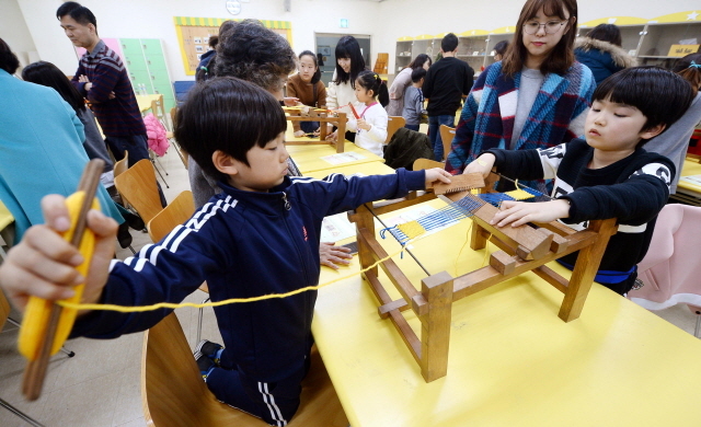 ▲ 26일 오후 휴일을 맞아 인천시 연수구 인천시립박물관을 찾은 가족단위 나들이객들이 호기심 어린 모습으로 길쌈체험을 하고 있다.장용준기자