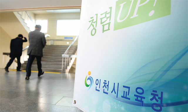 2월9일 억대 뇌물과 불법 정치자금 수수 혐의 등으로 이청연 인천시교육감이 법정 구속된 가운데 재판 방청을 마친 시 교육청 간부들이 당혹스러운 모습으로 인천시교육청 현관에 게시된 청렴 홍보판 옆을 지나고 있다.