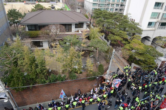 12일 오후 서울 강남구 삼성동 박근혜 전 대통령 사저 앞에 지지자들이 태극기와 성조기를 들고 탄핵 항의시위를 하고 있다.  /연합뉴스