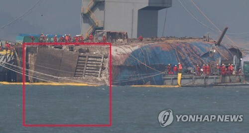 ▲ 23일 오후 전남 진도군 사고 해역에서 작업자들이 바다에서 떠오른 세월호 우현 선미 부분을 보고 있다. 해수부는 이날 긴급 브리핑을 열고 세월호의 좌현 선미 램프 부분(바닷속에 잠겨 있는 부분)이 열려 있어서 제거 작업을 하고 있다고 밝혔다. 이 램프를 제거하지 못하면 인근에 대기 중인 반잠수식 선박에 세월호를 싣지 못하게 된다.  /연합