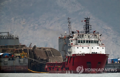 ▲ 24일 오후 전남 진도군 사고 해역에서 해수면 13m로 부상한 세월호가 잭킹바지선과 예인선의 도움으로 반잠수선으로 이동할 준비를 하고 있다. /연합