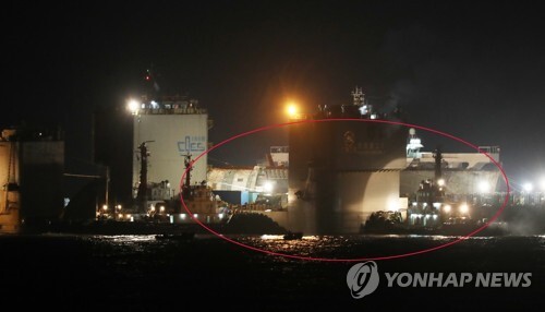 ▲ 24일 오후 세월호(빨간선 뒷 부분)가 반잠수식 선박에 도착, 선적작업을 하고 있다. /연합