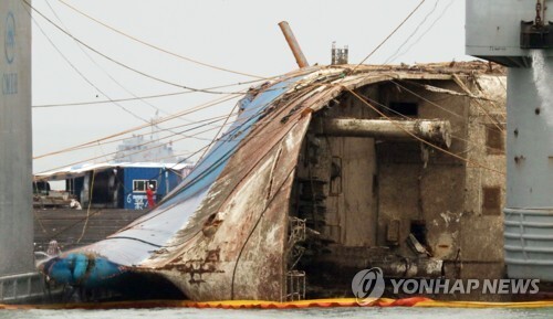 ▲ 24일 오후 전남 진도군 사고 해역에서 세월호가 반잠수선으로 이동 준비하며 처참한 선수를 드러내고 있다. /연합