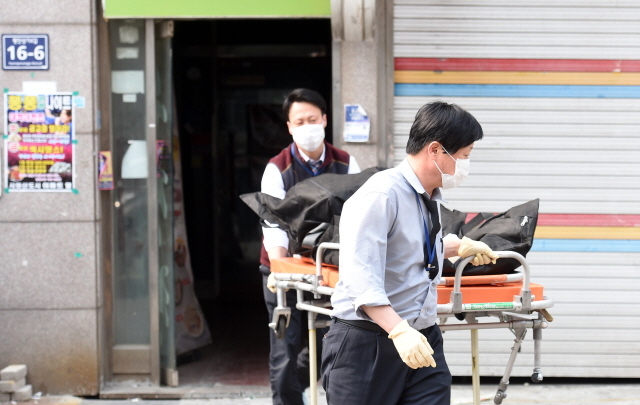  26일 오전 불에 탄 여성 시신이 발견된 시흥시 정왕동 한 원룸에서 관계자가 시신을 수습하고 있다. 반 알몸상태의 시신은 얼굴과 지문 등이 불에 훼손돼 신원을 확인하기 어려운 상태였다. 경찰은 수차례 흉기 상흔이 발견된 점으로 미뤄 누군가 여성을 흉기로 찔러 살해한 뒤 시신에 불을 놓은 것으로 추정하고 있다. 전형민기자