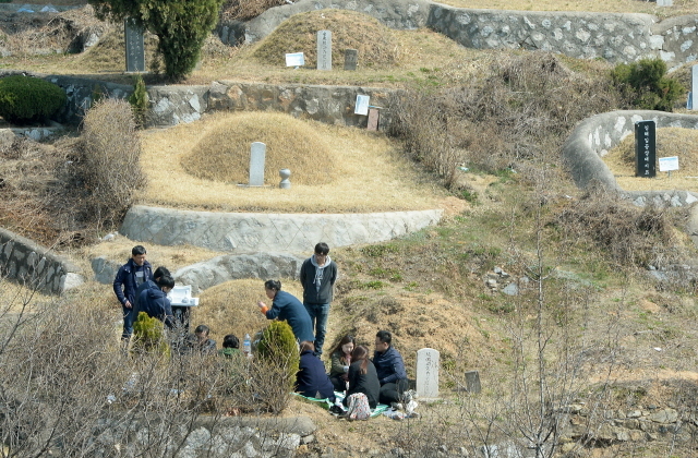 2일 오후 한식을 사흘 앞두고 휴일을 맞아 인천시 부평구 인천가족공원의 조상 묘소를 찾은 일가족들이 성묘를 하고 있다.장용준기자 