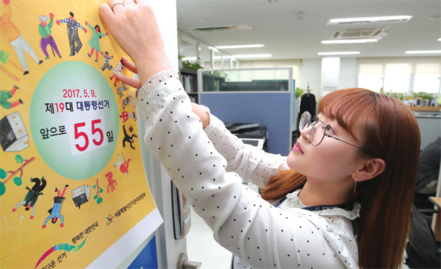 박근혜 전 대통령 파면으로 실시되는 조기 대통령 선거일이 5월9일로 확정된 3월15일 서울시선거관리위원회에서 직원이 선거일 D-Day 포스터를 붙이고 있다.