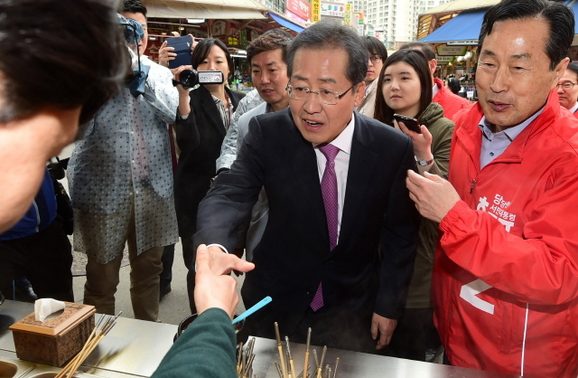 ▲ 자유한국당 홍준표 대선후보가 20일 오전 인천시 남동구 모래내시장을 찾아 한 어묵 점포에서 상인과 악수를 나누고 있다.장용준기자