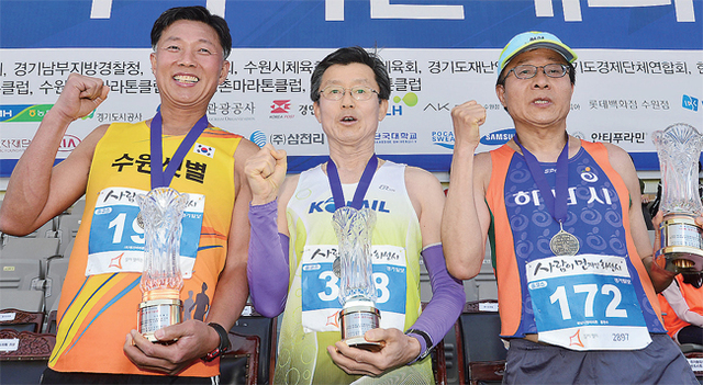 ▲ 풀코스 완주 100회를 기록한 (왼쪽부터)명홍진, 김관행, 홍현수 씨가 기념패를 들고 기념촬영을 하고 있다.  특별취재반