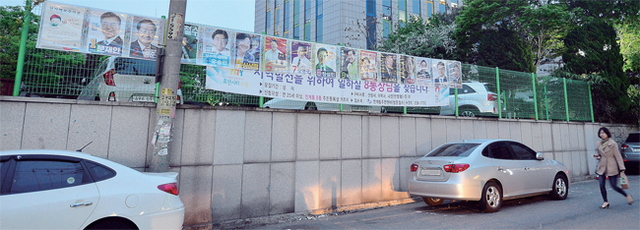 ▲ 공간 많은데… 전봇대에 가려진 후보 25일 수원시 팔달구 인계동 한 거리에 내걸린 ‘제19대 대통령선거’ 후보자 선전벽보가 우측에 여유 공간이 충분함에도 불구하고 전봇대 뒤에 부착돼 특정 후보의 모습이 가려져 보이지 않고 있다. 오승현기자