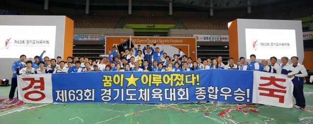 ▲ 제63회 경기도체육대회에서 1부 승격 20년 만에 첫 종합우승을 차지한 화성시 선수단이 우승기와 우승트로피를 들고 기념촬영을 하고 있다.경기도체육회 제공