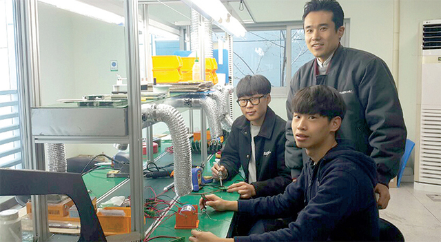 씨엔이지에스에서 학기업현장 교사와 학습근로자들이 수업 중 환하게 웃고 있다.
