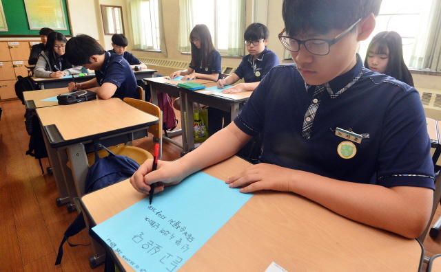 사춘기 학생들의 욕설, 비속어, 인터넷 용어 사용을 지양하고 올바른 언어 사용을 위해 학교가 나섰다. 18일 오전 수원 영통중학교에서 언어문화개선캠페인 ‘하는 말이 좋아야 오는 말이 좋다’에 참여한 학생들이 상처받았던 말과 듣고 싶은 말을 종이에 적고 있다. 오승현기자