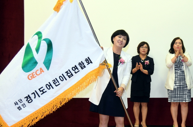 ▲ 30일 경기도의회 대회의실에서 열린 '제10, 11대 경기도어린이집연합회 회장 및 임원 이,취임식'에서 김경숙 신임 회장이 연합회기를 전달받고 있다. 김시범기자
