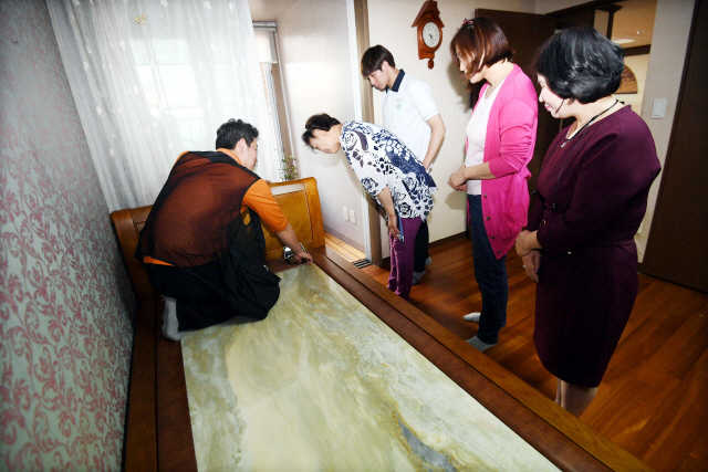 ▲ (주)가보건강침대로 부터 돌침대를 전달 받은 청각장애 수영선수 채예지 학생과 가족이 가보건강침대 관계자와 함께 돌침대를 살펴보고 있다.전형민기자