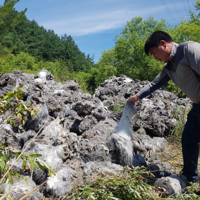 ▲ 5일 오전 10시께 안성시 금광면 삼흥리 A 골프장 입구 야산에 불에 탄 산업폐기물 상당량이 불법으로 투기된 현장을 한 주민이 손으로 가리키고 있다. 박석원기자