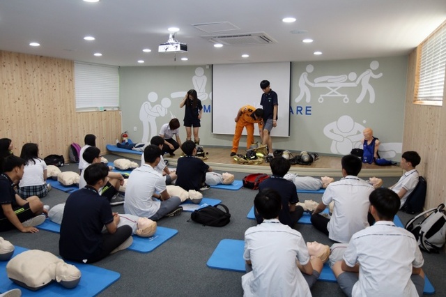 ▲ 직업특강에 참여한 신갈고 학생들이 화재진압 개인안전장비를 착용하고 있다.