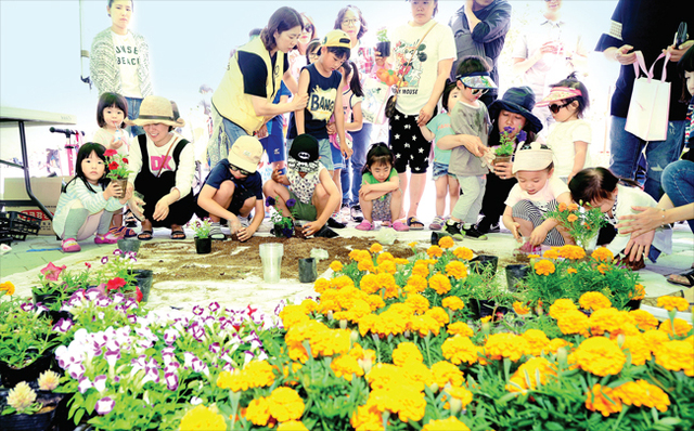 ▲ 10일 인천시 중구 영종도 씨사이드파크 하늘공원에서 열린 2017 영종 그린문화 축제 행사에서 환경캠페인에 참가한 가족들이 정성스레 친환경 화분을 만들고 있다. 장용준기자