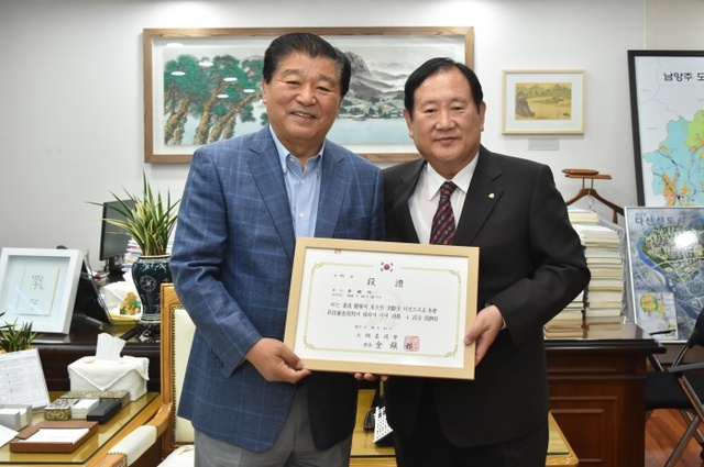 ▲ 이석우 남양주시장(왼쪽)이 12일 오후 시장 집무실에서 김진도 대한유도회장으로부터 공로 4단증을 전달받고 있다.대한유도회 제공