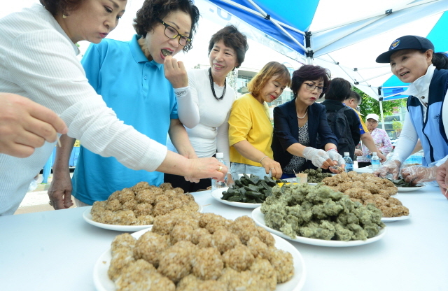 ▲ 21일 오전 인천시 남구 주안역 광장에서 열린 '한국자유총연맹 인천남구지회 6·25전쟁 음식 시식회'에서 시민이 6·25전쟁 당시 음식인 보리밥, 개떡, 쑥버무리를 시식하고 있다. 장용준기자