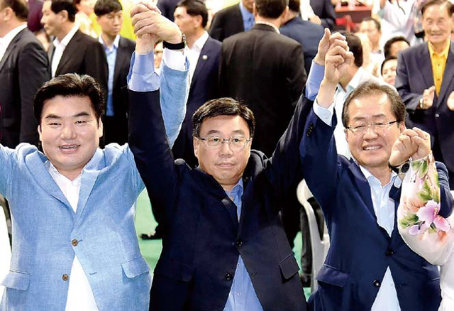 ▲ 29일 안양실내체육관에서 열린 ‘자유한국당 제2차 전당대회 수도권 합동연설회’에서 원유철(왼쪽부터), 신상진, 홍준표 당대표 후보가 손을 맞잡고 당원들에게 인사하고 있다. 전형민기자