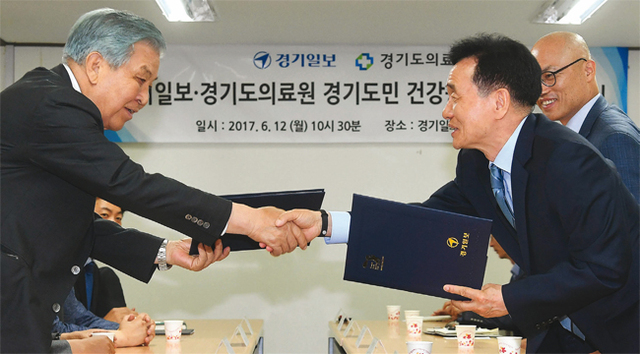 경기일보 중회의실에서 유병욱 경기도의료원장과 신항철 본보 대표이사 사장(왼쪽)이 협약서에 사인 후 악수를 나누고 있다. 