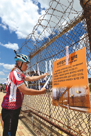 DMZ 평화문화광장에 도착한 참가자들이 비무장지대 철책에 통일의 염원을 담은 평화의 메시지를 달고 있다.