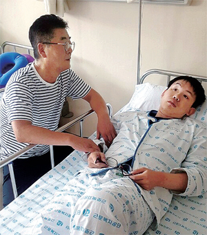  에스원에서 출동요원으로 일하다 교통사고를 당해 입원해있는 정두표씨(26) 곁에서 아버지인 정호진씨(53)가 간호를 하고 있다.