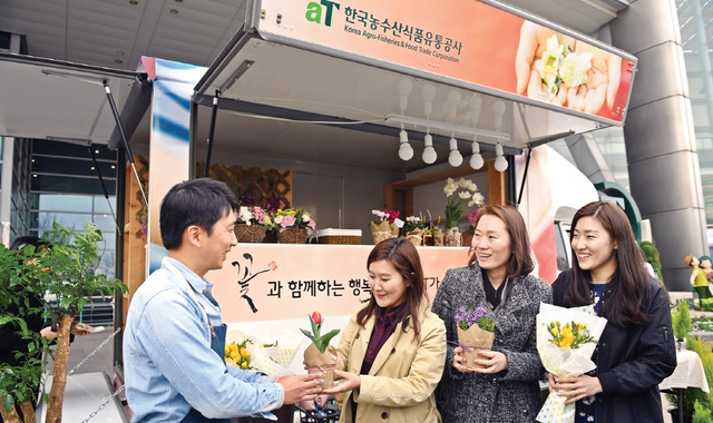 플라워트럭을 운영하는 청년 창업가가 소비자를 찾아가 꽃을 전달하고 있다.