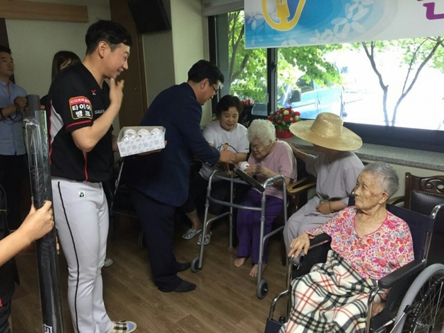 ▲ 21일 임종택 kt wiz 단장과 임직원이 광주시 퇴촌면에 위치한 ‘나눔의 집’을 방문해 위안부 할머니 및 봉사자들과 함께 하는 마술공연, 응원행사를 진행한 뒤 기념품을 전달하고 있다. kt wiz 제공