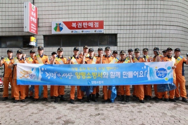 ▲ 양평소방서 소방대원들이 양평시내에서 청렴문화확산 캠페인을 펼치며 거리청소등 봉사활동도 병행했다.