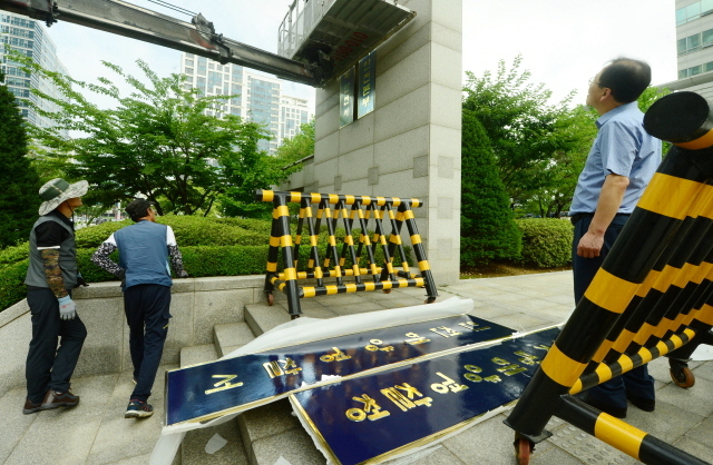 ▲ 정부조직법 개정에 따라 국민안전처 소속이던 해양경비안전본부가 해양경찰청으로 독립한다. 조직 개편을 하루 앞둔 25일 오전 인천시 연수구 송도동 중부해양경비안전본부 정문에서 외주직원들이 현판 교체작업을 하고 있다.장용준기자