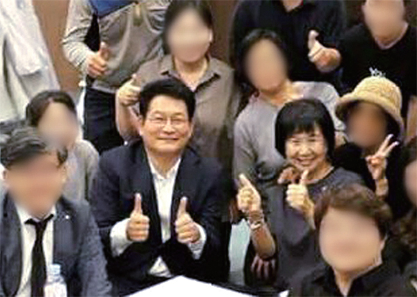 ▲ 더불어민주당 송영길, 손혜원 의원(네번째)이 지난 24일 ‘일본군 위안부’ 피해자인 고(故) 김군자 할머니의 빈소가 차려진 성남 분당 차병원 장례식장에서 엄지손가락을 치켜세우고 밝은 표정으로 기념사진을 촬영해 25일 인터넷에서 논란이 되고 있다. 트위터 캡처