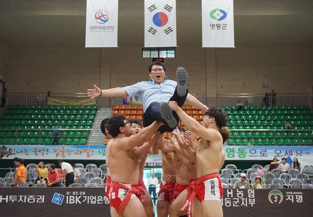 ▲ 27일 충북 영동체육관에서 열린 제54회 대통령기 전국장사씨름대회 일반부 단체전에서 6년 만에 우승을 차지한 용인백옥쌀 선수들이 장덕제 감독을 행가레치고 있다.대한씨름협회 제공