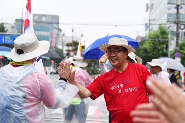 원경희 시장이 5박6일간의 일정으로 출발하는 여주사랑 걷기대회 참가자들과 하이파이브를 하고 있다. 여주시 제공.