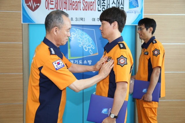 ▲ 김종현 서장이 성기현 소방교에게 하트세이버 엠블럼을 부착하고 있다.