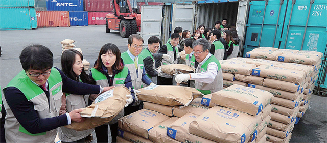 2014년 3월12일 오전 인천시 중구 항동 영진공사 보세창고에서 초록우산 어린이재단 자원봉사자들이 북한에 지원할 밀가루와 콩가루 200t을 컨테이너에 싣고 있다. 경기일보 DB