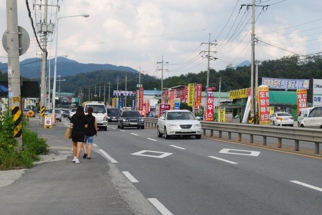 ▲ 지난 5일 오후 3시께 남양주시 일패동 경춘국도에서 시민 2명이 빠른 속도로 지나는 차량 사이로 아슬아슬하게 통행하고 있다. 하지은기자 (2)