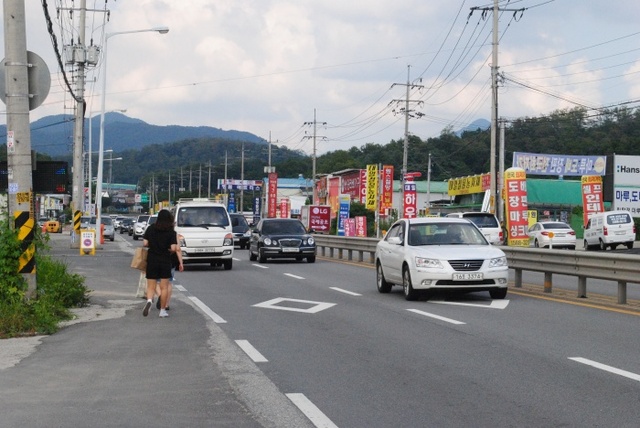 ▲ 지난 5일 오후 3시께 남양주시 일패동 경춘국도에서 시민 2명이 빠른 속도로 지나는 차량 사이로 아슬아슬하게 통행하고 있다. 하지은기자 (3)