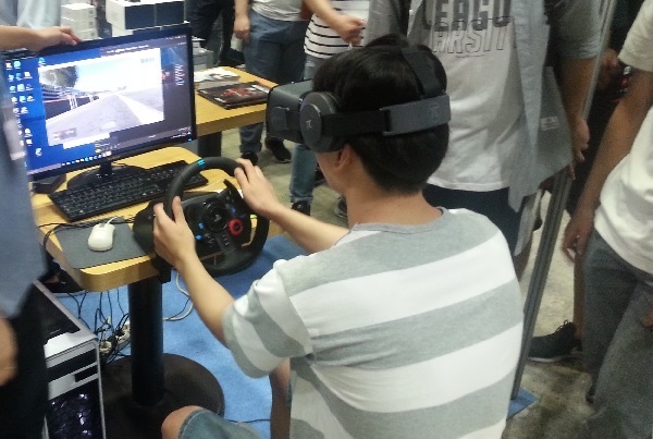 ▲ 스마트 디바이스 쇼 전시회 관람객이 직접 VR스포츠카 체험을 하고 있다. 사진/백상일기자