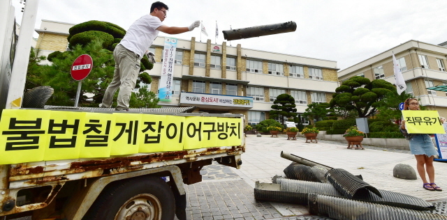 ▲ 28일 오전 인천시 중구 중구청 앞에서 인천녹색연합 회원들이 중구 영종도 서쪽 갯벌(용유해변)에서 수거한 칠게잡이 불법 어구를 내던지며 어구 철거를 촉구하는 퍼포먼스를 하고 있다.장용준기자
