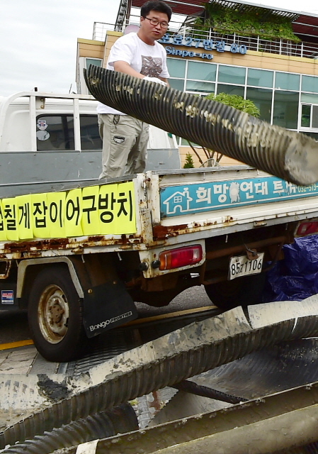 ▲ 28일 오전 인천시 중구 중구청 앞에서 인천녹색연합 회원들이 중구 영종도 서쪽 갯벌(용유해변)에서 수거한 칠게잡이 불법 어구를 내던지며 어구 철거를 촉구하는 퍼포먼스를 하고 있다.장용준기자