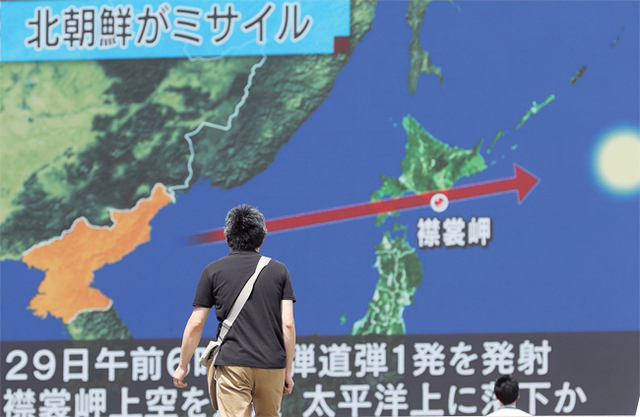 충격 휩싸인 日 29일 새벽 북한이 발사한 미사일이 일본 상공을 통과한 가운데 도쿄에서 한 시민이 관련 뉴스를 시청하고 있다. 이날 북한의 미사일 발사 직후 일본 정부는 일부 지역 주민들을 대피시키고 긴급사태 속보를 휴대전화를 통해 송출했다. EPA 연합뉴스