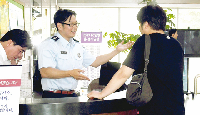 기자가 안내데스크에서 민원인을 응대하고 있다.